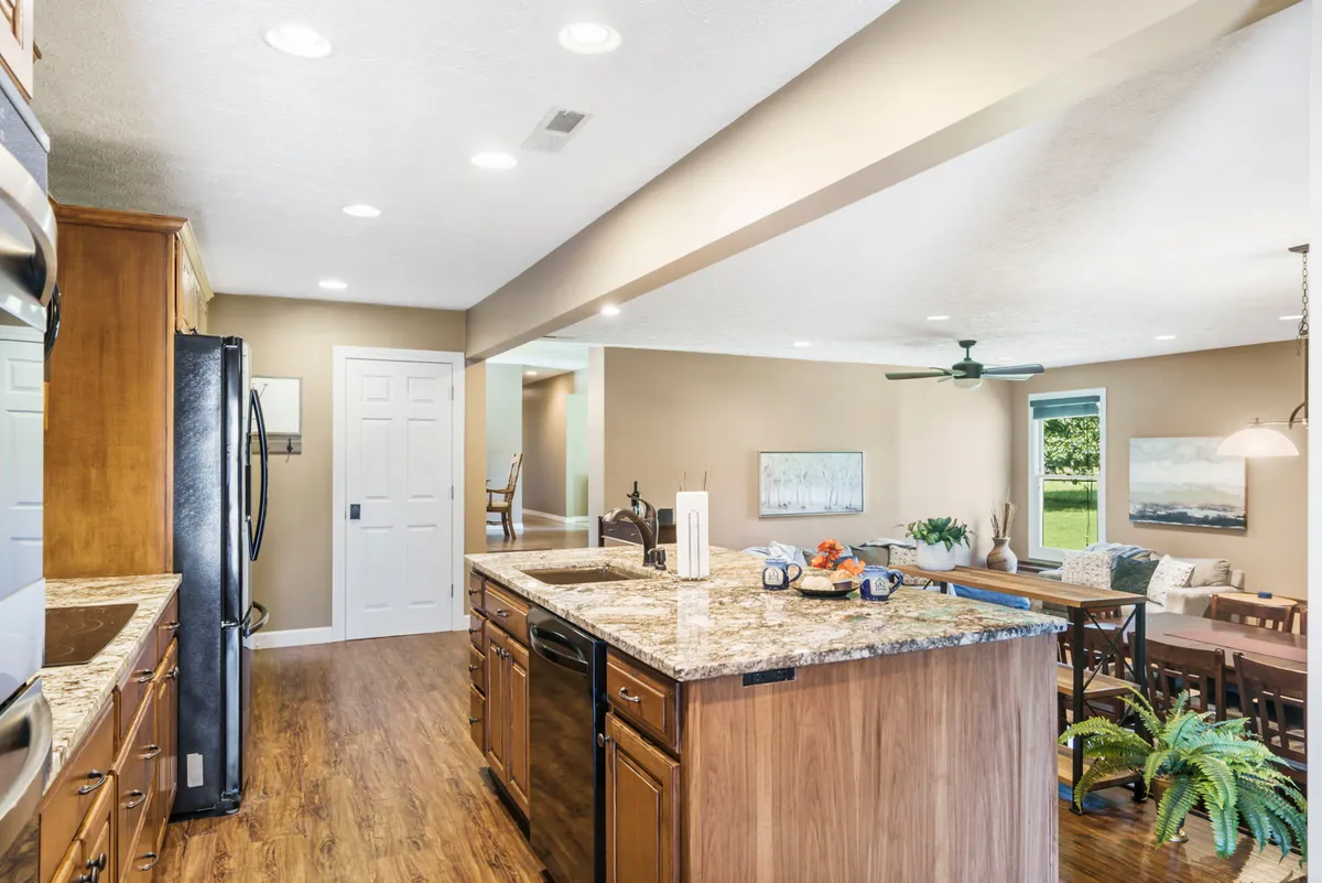 A kitchen and dining area highlighted by a granite countertop kitchen island, a bright dining area, and large windows that let in natural light. The layout encourages both cooking and communal dining experiences.